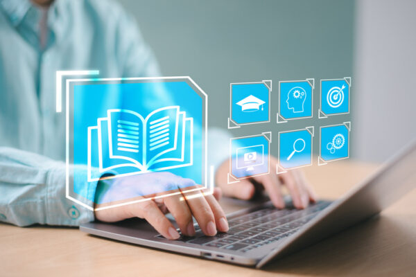 A student using a laptop with various app icons.